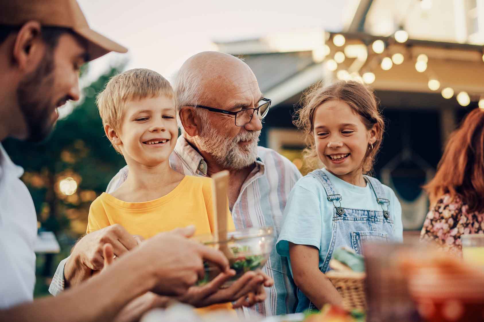 Happy senior grandfather talking and having fun with his grandchildren